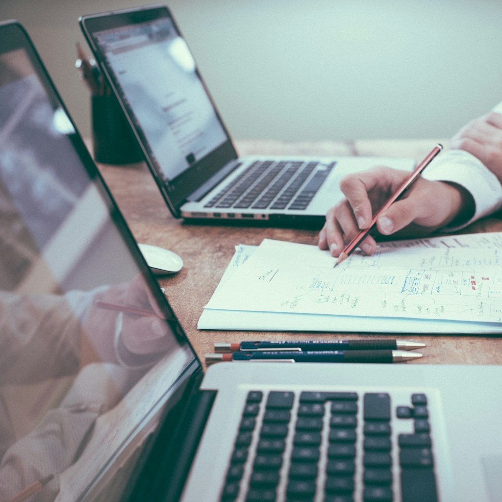 Reviewing financial documents beside a laptop